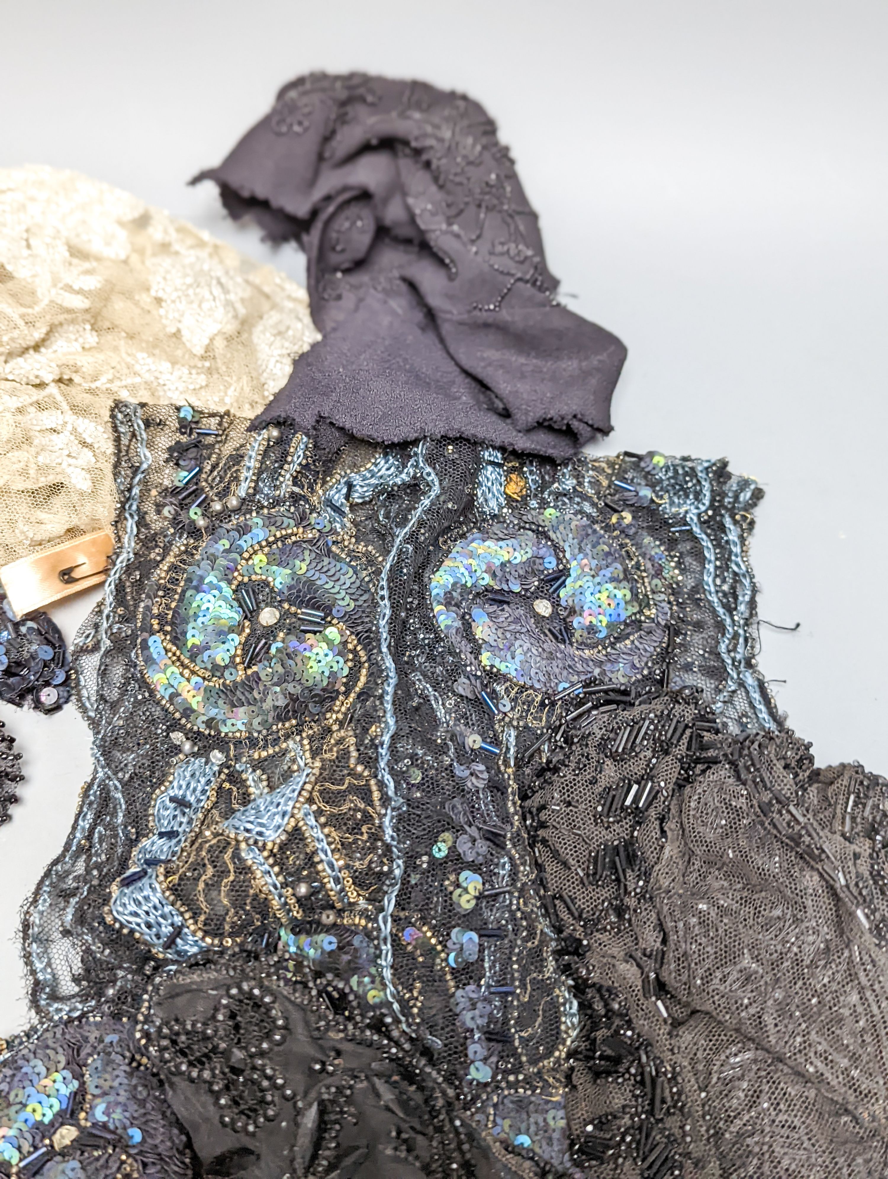 A collection of Edwardian and later sequin and beaded panels on net, a black beaded stole, various buttons etc.